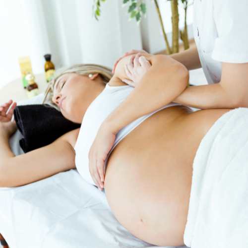 a woman on her side receiving pregnancy massage